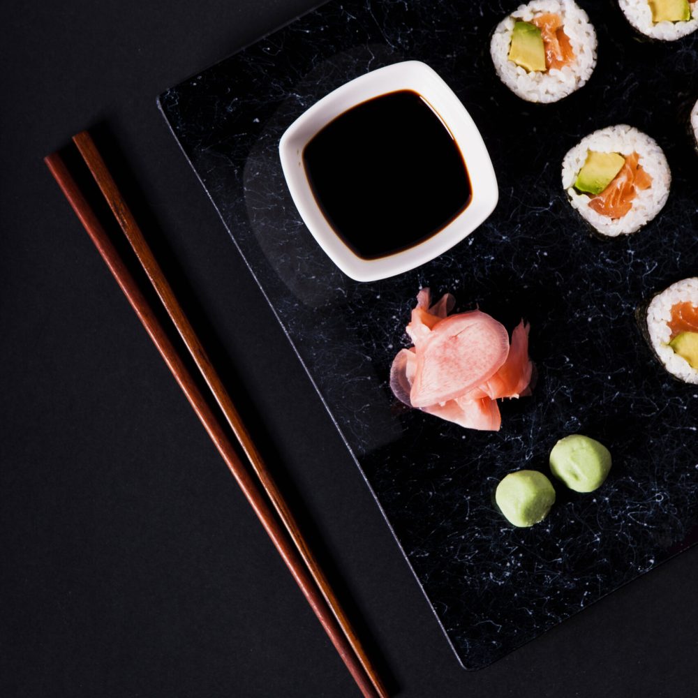 chopsticks-near-crop-plate-with-sushi