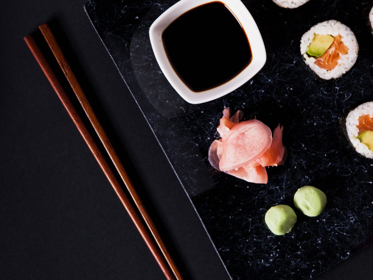 chopsticks-near-crop-plate-with-sushi